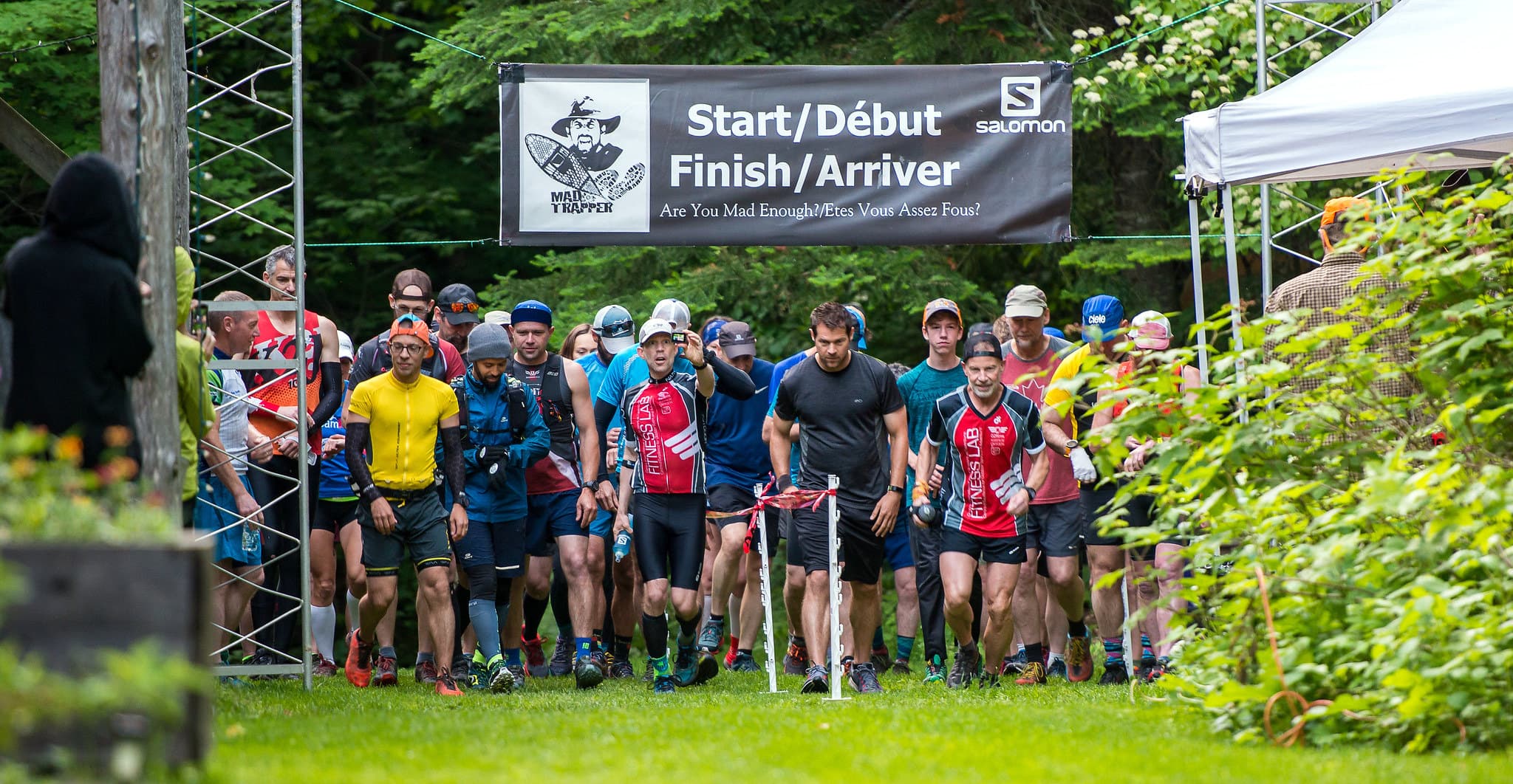 Runners gather beneath a branded Mad Trapper start and finish banner